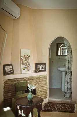 a bathroom with a sink and a table with a vase at Auberge Ayam Atlas- pool 10mn away in Ourika