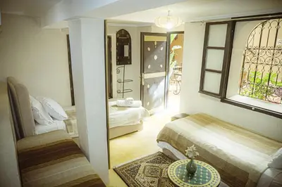 a bedroom with a bed and a window and a table at Auberge Ayam Atlas- pool 10mn away in Ourika