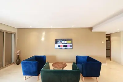 a living room with blue chairs and a table at Prestigia Fès in Fès