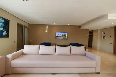 a living room with a couch and blue chairs at Prestigia Fès in Fès