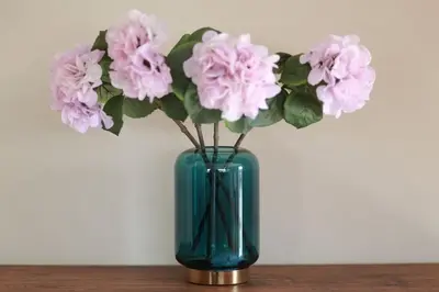 a blue vase filled with pink flowers on a table at Prestigia Fès in Fès