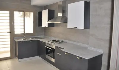 a kitchen with a sink and a stove top oven at Prestigia Fès in Fès