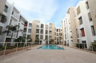 an apartment complex with a swimming pool in a courtyard at Prestigia Fès in Fès