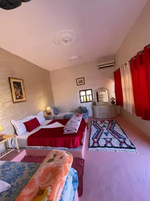a bedroom with two beds and a couch in it at Hôtel familiale les grotte in Aït Ben Haddou