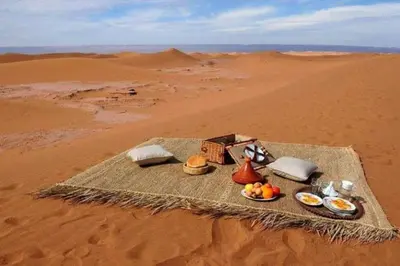 a table in the desert with food on it at Mhamid Tours in Mhamid