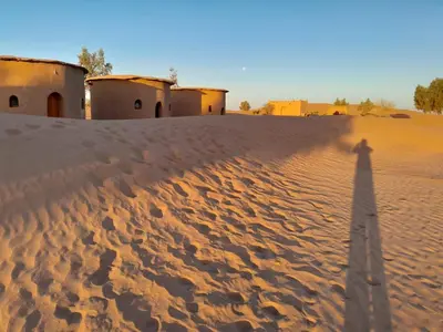 a shadow of a person standing in the desert at Mhamid Tours in Mhamid