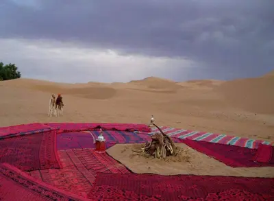 two people are riding horses in the desert at Mhamid Tours in Mhamid