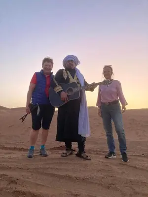 a group of three people standing in the desert at Mhamid Tours in Mhamid