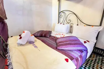 a bed with two stuffed animals sitting on top of it at Dar Attajalli in Fès
