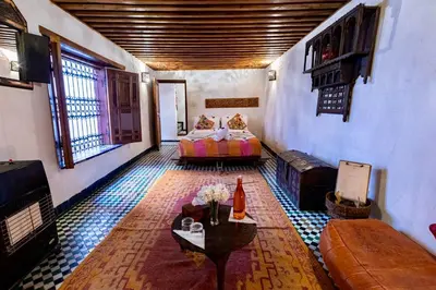 a room with two beds and a couch in a room at Dar Attajalli in Fès