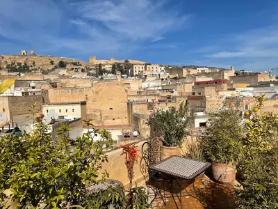 a view of a city from a balcony with a table at Dar Attajalli in Fès