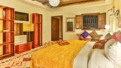 a bedroom with a large bed with a yellow blanket at ferme by Ikalimo in Ourika