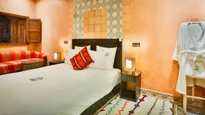 a bedroom with a bed and a red couch at ferme by Ikalimo in Ourika