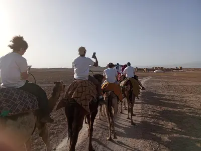 a group of people riding horses in the desert at Auberge Restaurant TISSILI 