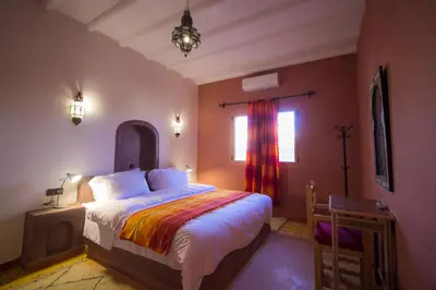 a bedroom with a bed and a window at Hassilabiad Appart Hotel in Merzouga