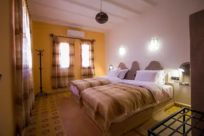 a bedroom with a large bed and a window at Hassilabiad Appart Hotel in Merzouga