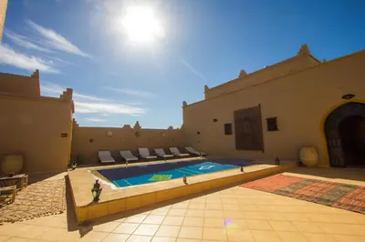 a swimming pool in the middle of a building at Hassilabiad Appart Hotel in Merzouga