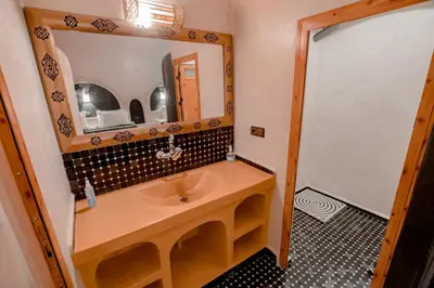 a bathroom with a sink and a mirror at Hassilabiad Appart Hotel in Merzouga