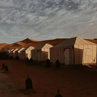 a row of white tents in the desert at Erg Chigaga Camp Shooting Stars in Mhamid