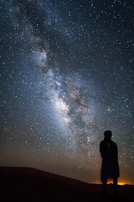 a man standing in front of a starry sky at Erg Chigaga Camp Shooting Stars in Mhamid