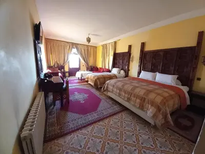 a hotel room with two beds and a window at Hotel Kasbah Asmaa in Midelt