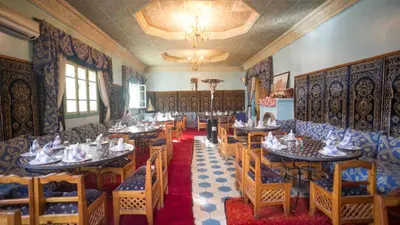 a restaurant with tables and chairs in a room at Hotel Kasbah Asmaa in Midelt