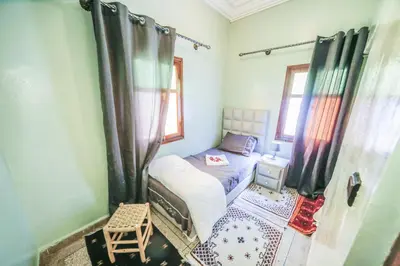 a small bedroom with a bed and a window at Dar Widad in Ouarzazate