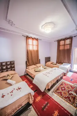 a room with three beds in a room at Dar Widad in Ouarzazate