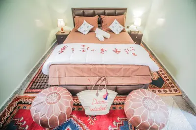 a bedroom with a large bed with a rug at Dar Widad in Ouarzazate