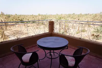 a table and chairs on a balcony with a view at Riad Zagora Palms in Zagora