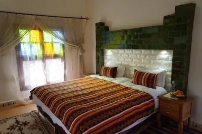 a bedroom with a large bed and a window at Riad Zagora Palms in Zagora
