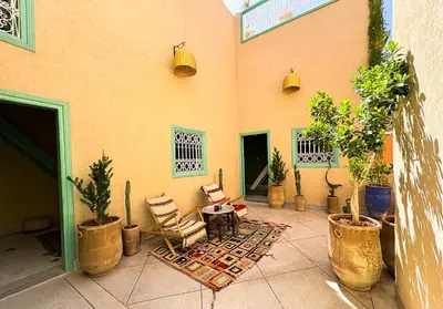 a patio with potted plants and a table and chairs at Dar Soufian in Ouarzazate