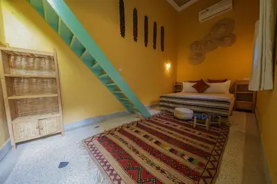 a bedroom with a bed and a staircase with a rug at Dar Soufian in Ouarzazate