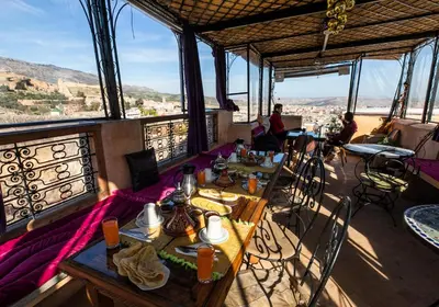 a restaurant with tables and chairs with a view at Dar Naima in Fès