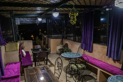 a patio with purple chairs and tables and windows at Dar Naima in Fès