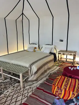 a bedroom with a bed and a table at Bivouac Luna in Mhamid