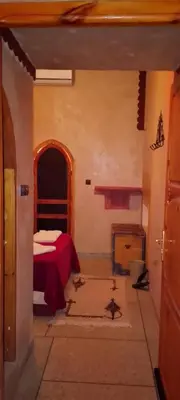 a bedroom with a bed in a room with a fireplace at Auberge Restaurant Zahra in Boumalne