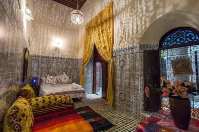 a bedroom with a bed and a couch in a room at Dar Lalla Kenza in Fès
