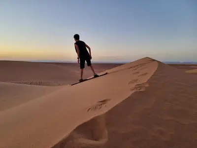 a man standing on top of a sand dune at Authentique berber Camp & Activities in Mhamid