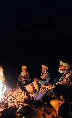 a group of people sitting around a fire at Authentique berber Camp & Activities in Mhamid