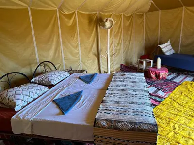 a large bed in a tent with pillows on it at Authentique berber Camp & Activities in Mhamid