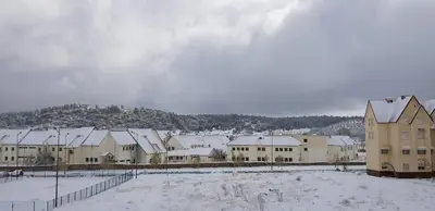 a group of buildings with snow on the ground at Un havre de paix à Ifrane in Ifrane