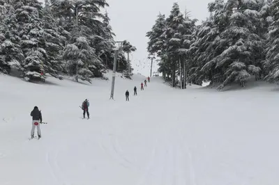 a group of people skiing down a snow covered slope at Un havre de paix à Ifrane in Ifrane