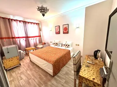 a hotel room with a bed and a couch at Hotel Riad Amlal in Ouarzazate