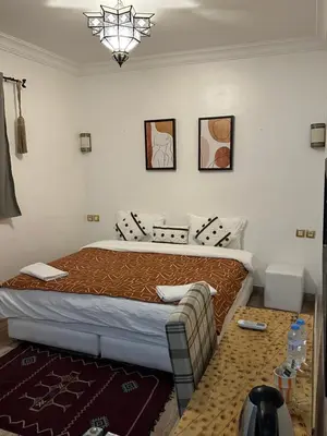 a bedroom with a bed and a couch at Hotel Riad Amlal in Ouarzazate