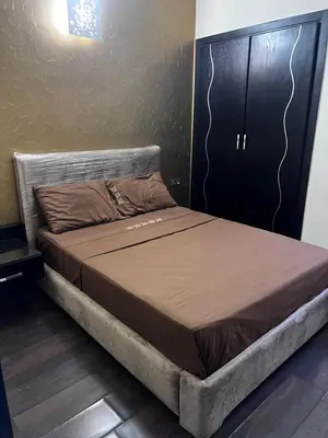 a large bed in a bedroom with a black cabinet at top Appartement in Fes City Marbella House in Fès