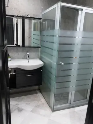 a bathroom with a glass shower and a sink at top Appartement in Fes City Marbella House in Fès