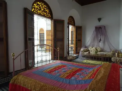 a bedroom with a large bed with a rug on the floor at Dar Al Safadi in Fès