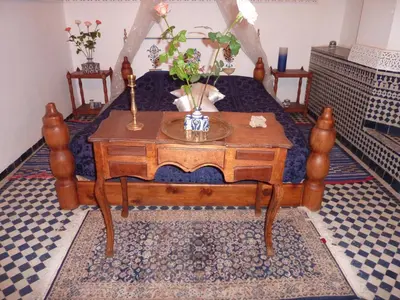 a bed with a table with flowers on it at Dar Al Safadi in Fès