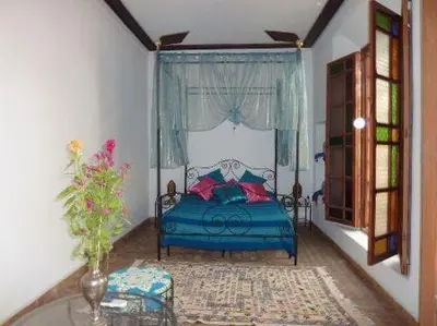 a bedroom with a blue bed and a window at Dar Al Safadi in Fès